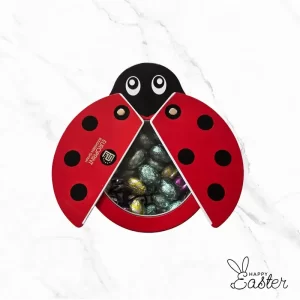 Метална великденска калинка с отварящи се крила, пълна с цветни шоколадови яйца.